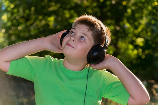 Junge hört Musik mit Kopfhörern im Park — Stockfoto
