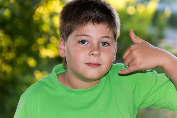 De jongen toont gebaar oproep in de natuur — Stockfoto
