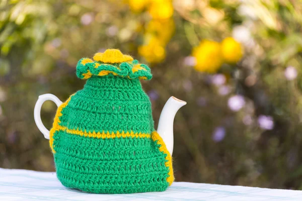 Gebreide kleedje op de theepot op natuurlijke achtergrond. — Stockfoto