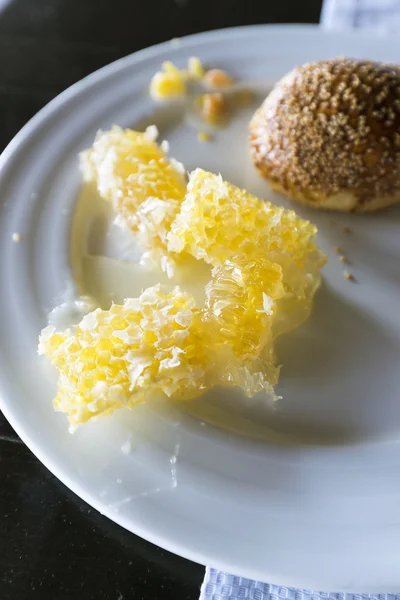 Pettine di miele e croissant sul piatto — Foto Stock
