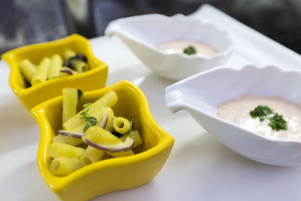 Sallad med pasta och sås i portionde tallrikar — Stockfoto