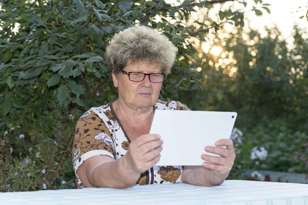 Oma mit Enkel schaut Tablet in der Natur — Stockfoto