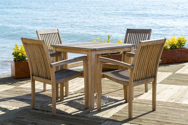 木桌和椅子在海边的咖啡馆 — 图库照片