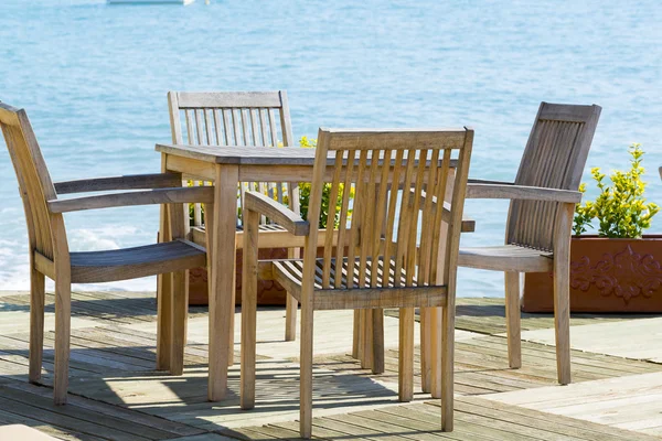 Cafe met houten tafels en stoelen op zee — Stockfoto