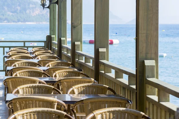 Café mit Holztischen und Stühlen am Meer — Stockfoto