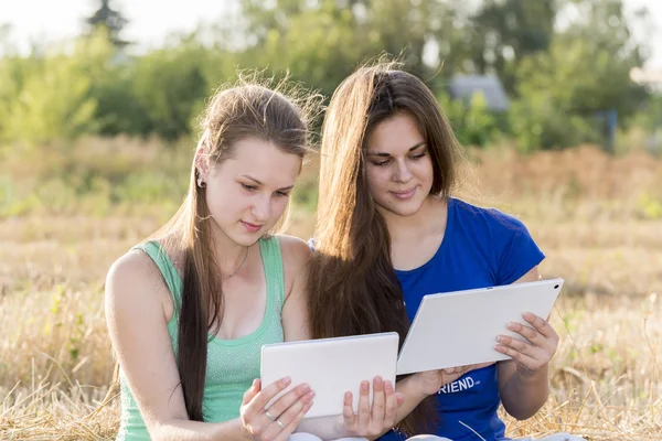 Dvě teen dívky s počítačem Tablet Pc v přírodě — Stock fotografie