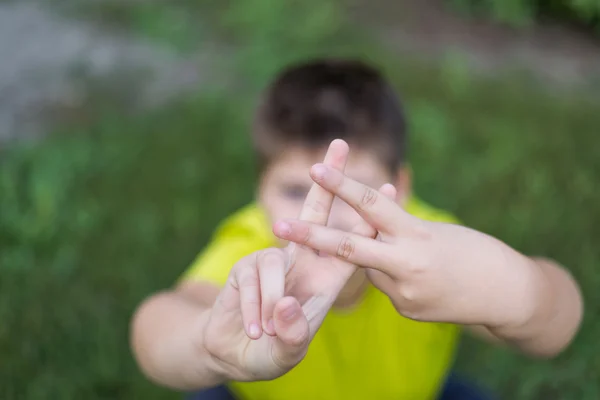 Boy shows sign gesture prison bars — Stock Photo, Image