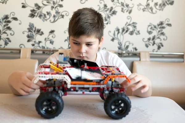 Chłopiec gra zbiera od konstruktora samochodu — Zdjęcie stockowe