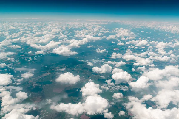 View of  land, fields, and clouds from above