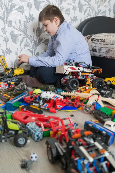 Teenage boy playing with toy cars in  room — Stock Photo, Image