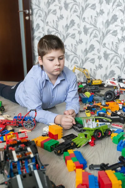 Adolescent garçon jouer avec jouet voitures dans chambre — Photo