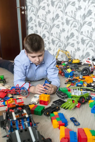 Teenage boy playing with toy cars in  room — Stock Photo, Image