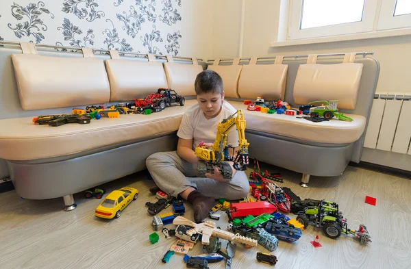 Teenage boy playing with toy cars in  room — Stock Photo, Image