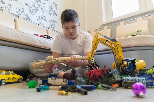 Teenage boy playing with toy cars in  room — Stock Photo, Image