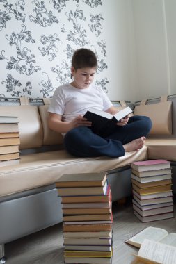 Genç çocuk odasında bir kitap okuma