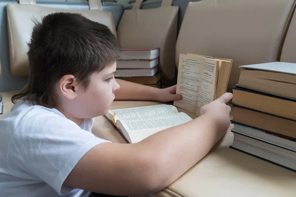 Tonåring pojke läser en bok i rum — Stockfoto