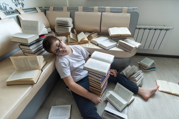 Tired boy sleeping surrounded by books in  room — Stock Photo, Image