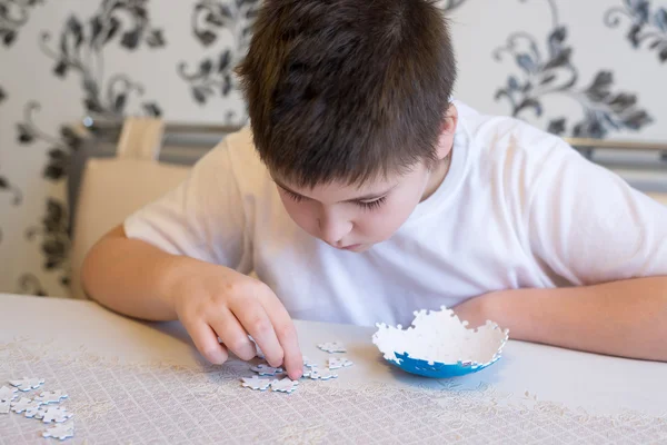 Teenager boy collects puzzles from Globe — Stock Photo, Image