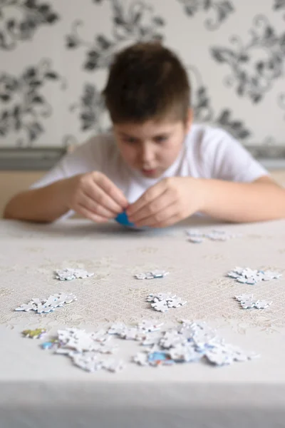 10 代の少年は、世界中からパズルを収集します。 — ストック写真