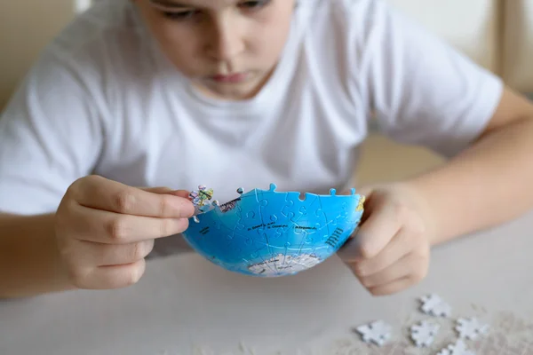 Teenager boy collects puzzles from Globe — Stock Photo, Image