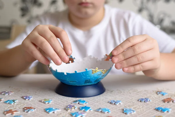 Teenager boy collects puzzles from Globe — Stock Photo, Image