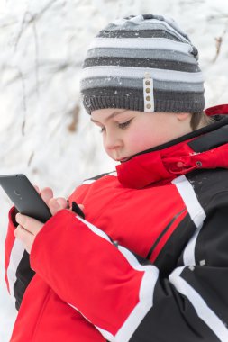 Genç çocuk sms kış parkta yazıyor.