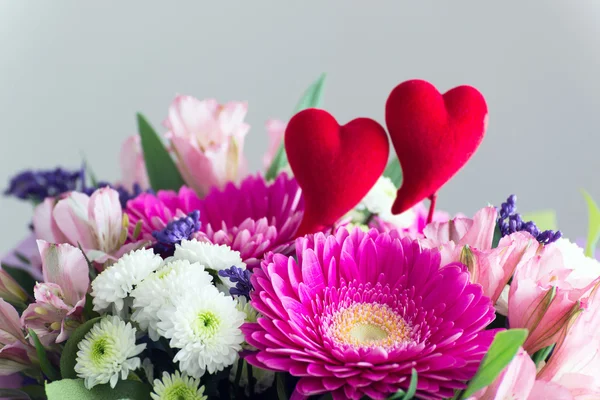 Red hearts and a bouquet of flowers — Stock Photo, Image