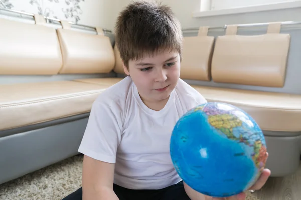 Menino estudando globo na sala — Fotografia de Stock