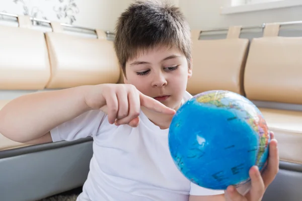 Boy studying globe in the room — Stock Photo, Image