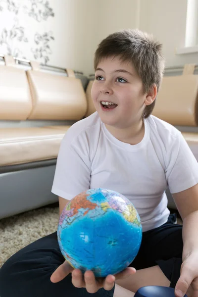 Boy studying globe in the room — Stock Photo, Image