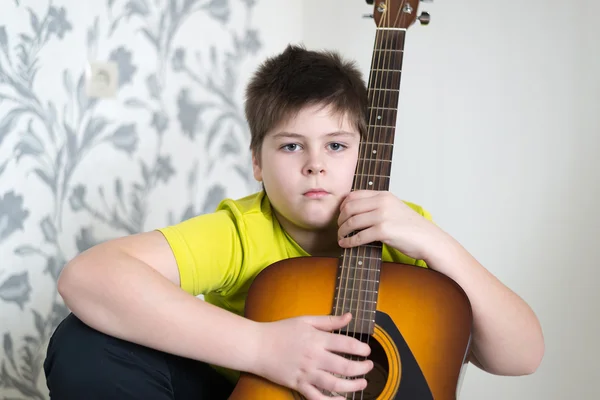 Adolescente chico juega una guitarra acústica — Foto de Stock