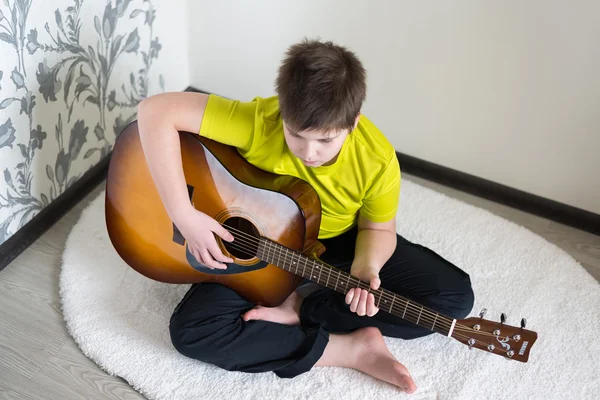 Teenage Boy plays an acoustic guitar — Stock Photo, Image