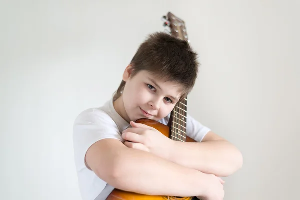 Tonårspojke spelar en akustisk gitarr — Stockfoto