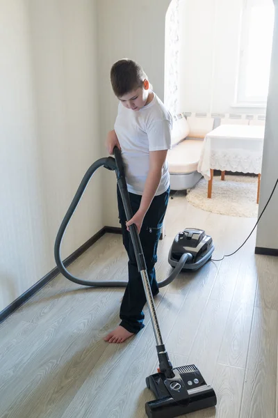 Kind met behulp van stofzuiger in huis — Stockfoto