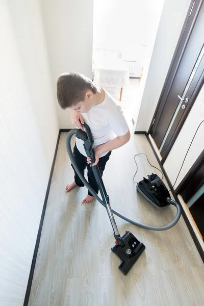 Kind met behulp van stofzuiger in huis — Stockfoto