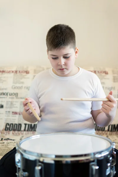 Pojke tonåring spelar trummor i rum — Stockfoto