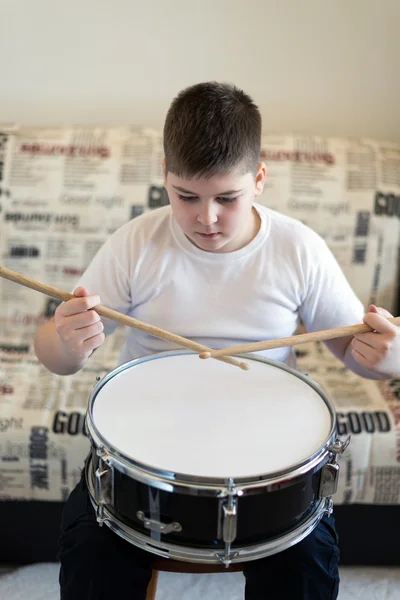 Dospívající chlapec hraje na bicí nástroje v místnosti — Stock fotografie