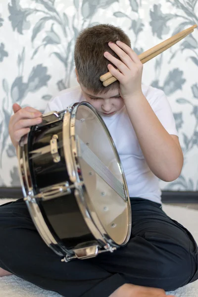 Jugendlicher Junge mit Trommel hält seinen Kopf — Stockfoto