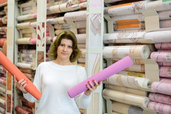 Woman buys wallpaper in  store — Stock Photo, Image