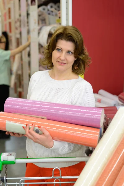 Woman buys wallpaper in  store — Stock Photo, Image