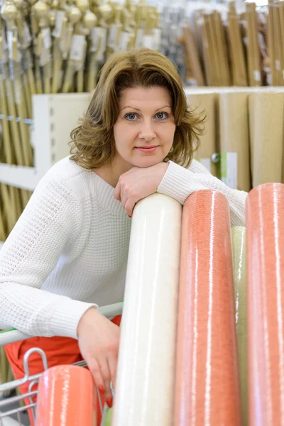 Woman buys wallpaper in  store — Stock Photo, Image