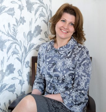 Orta yaşlı kadın sandalyede oturma odasında oturuyordu