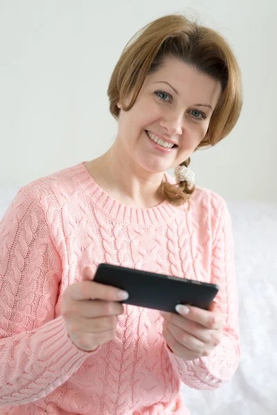 Positiv kvinna med mobiltelefon i handen — Stockfoto