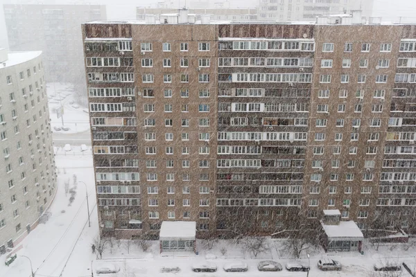 Chute de neige sur fond de façade du bâtiment résidentiel. Humeur hivernale — Photo