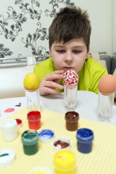 Garçon peint les oeufs de Pâques avec un pinceau — Photo