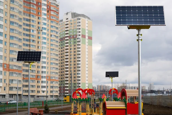 Children's playground in the courtyard of an apartment house with solar panels — Stock Photo, Image