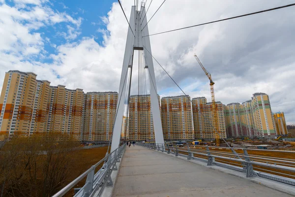 Krasnogorsk, RUSSIA - April 18,2015. Pedestrian bridge is built from two pylons, each measuring 41 m tall. Pylons are connected to spans with help of 28 straight cable wires, which hold up suspension — Stock Photo, Image