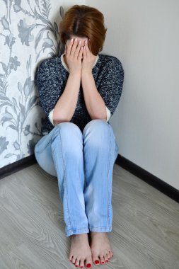 Kadın odanın köşesinde oturan depresyon ile