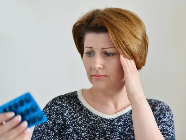 Mujer adulta tomando una pastilla para el dolor de cabeza — Foto de Stock