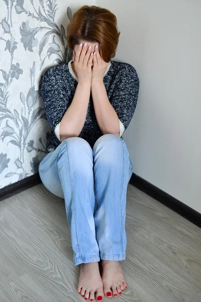 Frau mit Depressionen sitzt in der Zimmerecke — Stockfoto